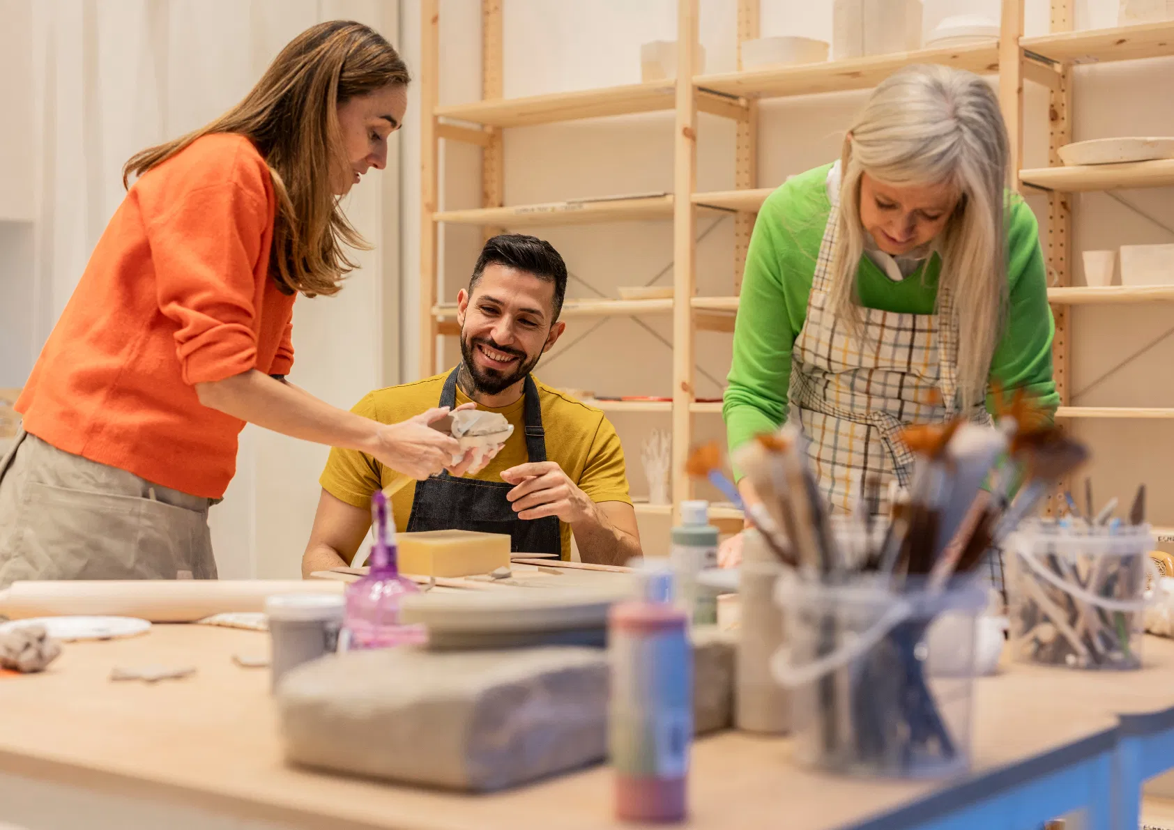Trois personnes en atelier artisanal de poterie