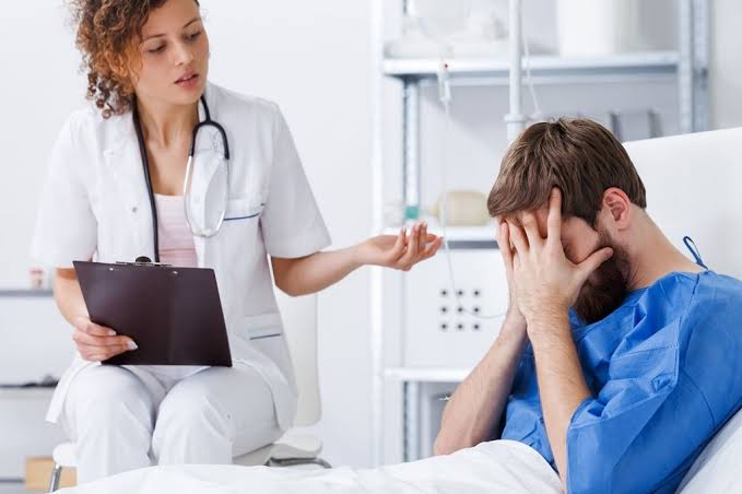 A doctor is listening to his patient's lungs with a stethoscope.