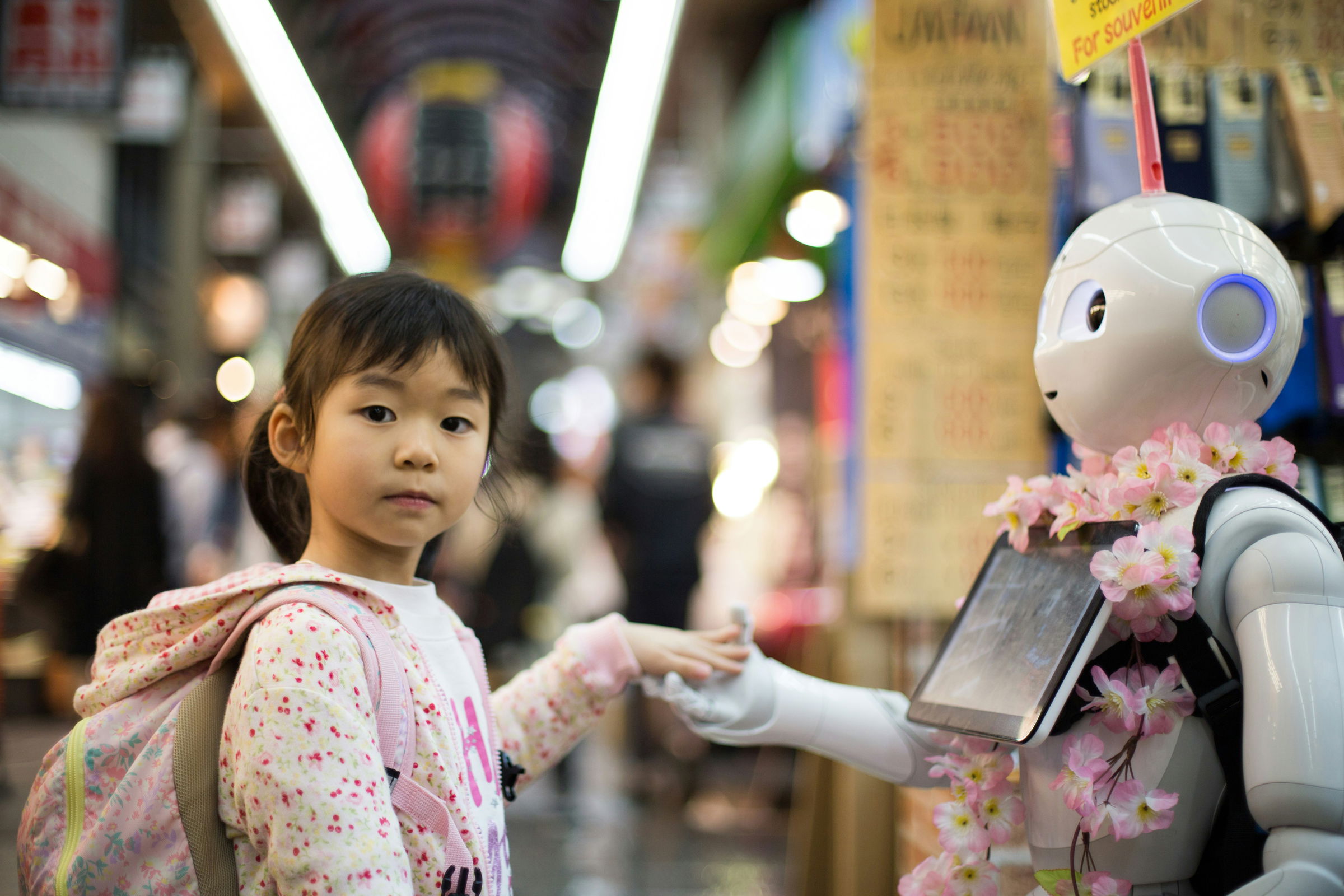 Child holding hands with Artificial Intelligence robot
