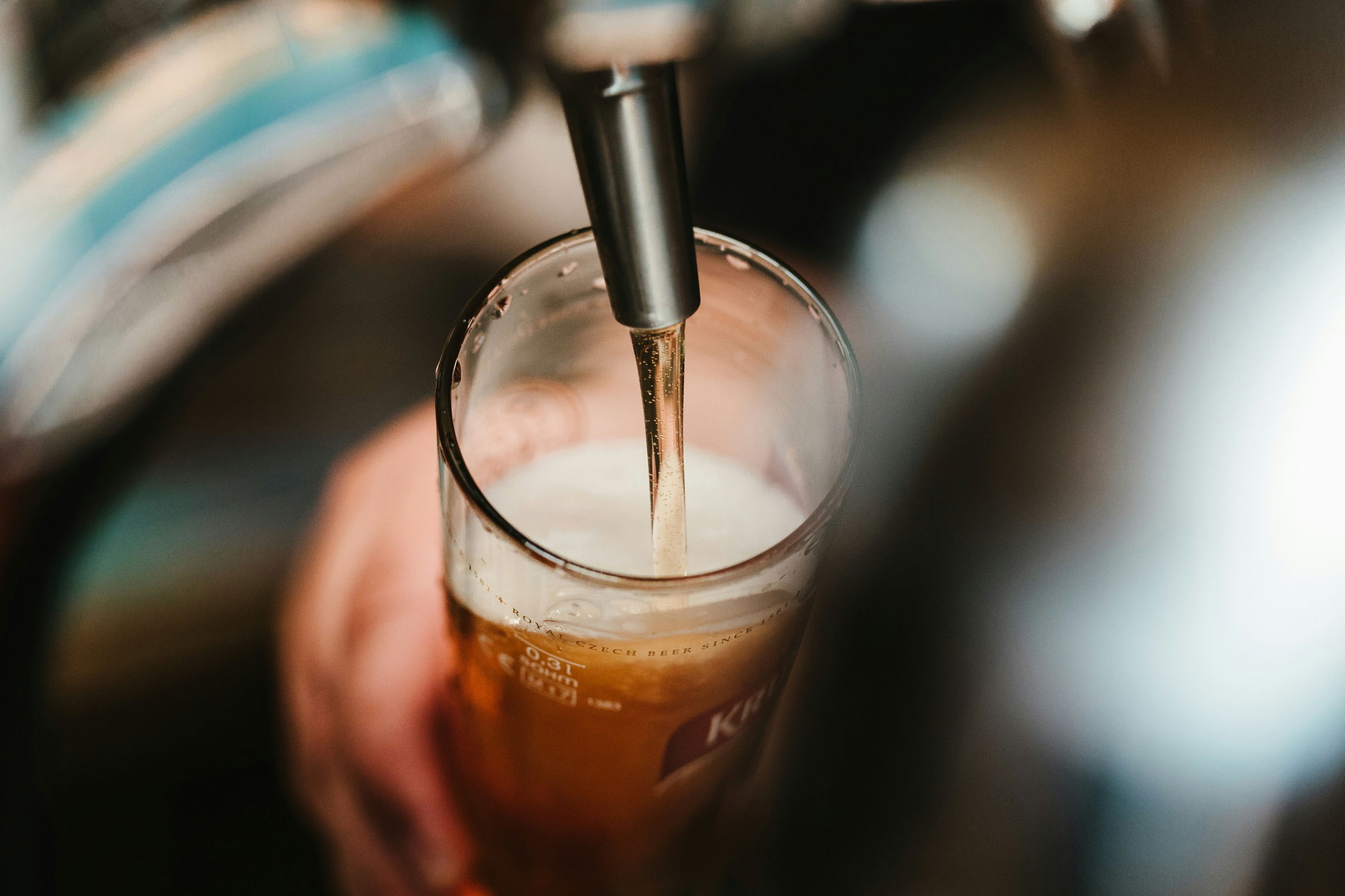 Close-up of a cold beer being poured from a draft tap system, representing professional bar and beverage installations by All Phase Service & Construction in Utah.