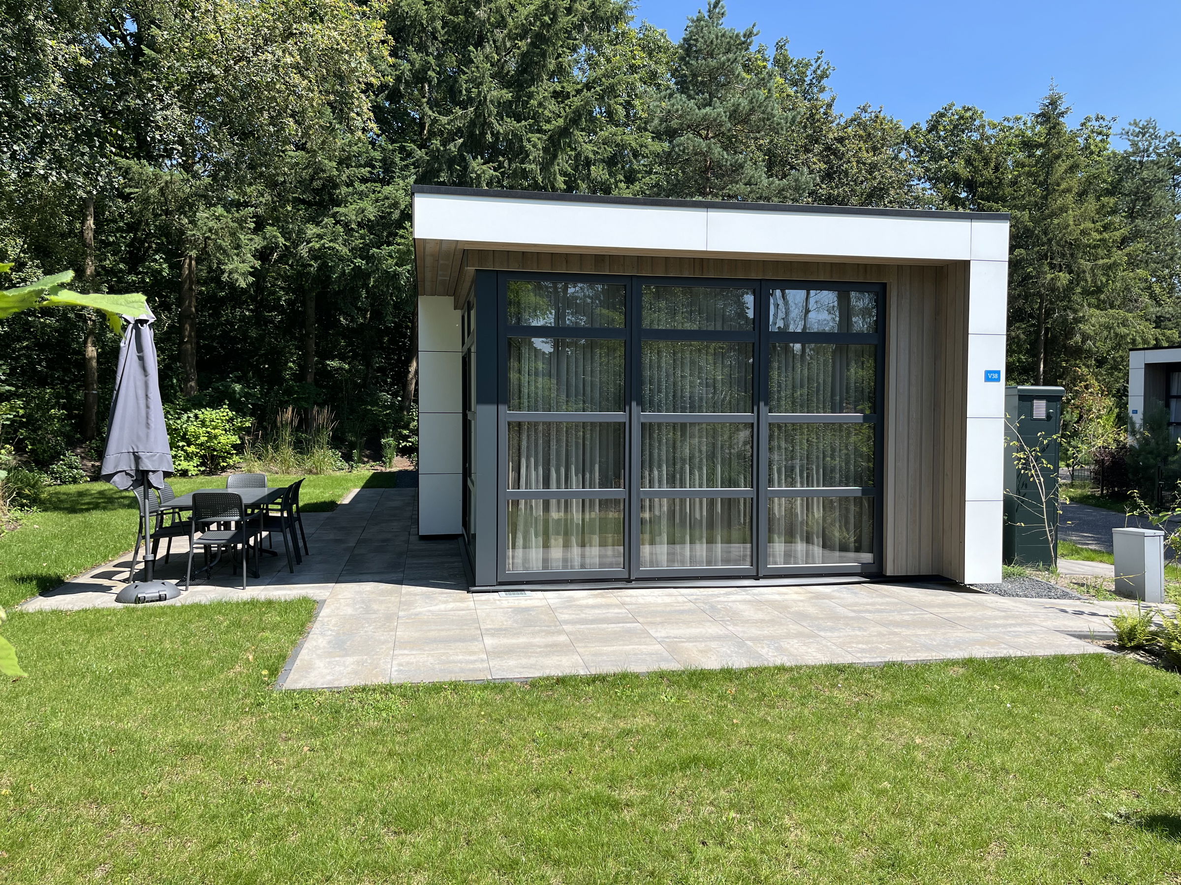 Front terrace with large glass windows and cozy seating area overlooking the garden