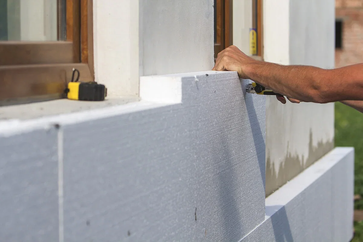 Pose d'isolation thermique par l'extérieur (ITE) avec mètre de mesure