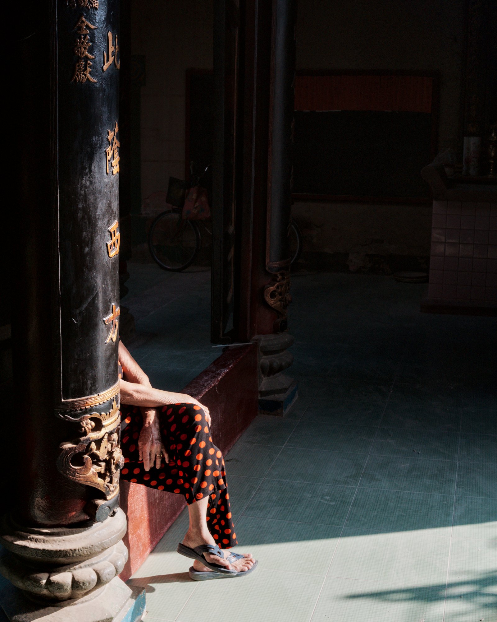 a vietnamese woman sitting in the shadow