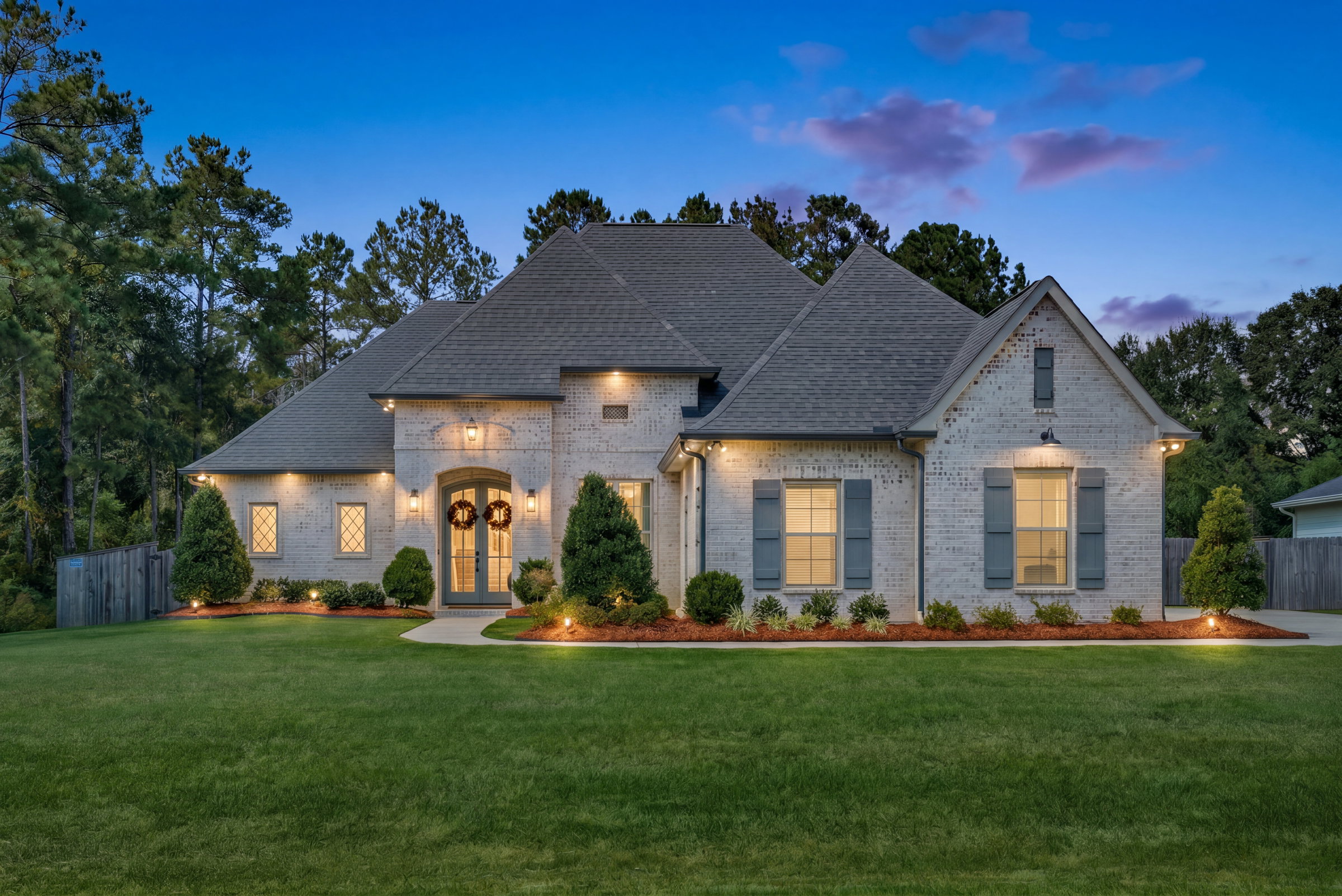 Straight-on ground-level twilight photograph of a home's exterior in Mandeville, Louisiana, captured by pompo.media.